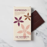A box of Gearharts Espresso Fine Chocolates next to a dark chocolate bar, displayed on a white marble surface.