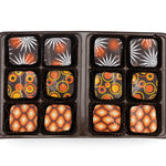Assorted chocolates in a black box on a white background