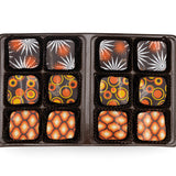 Assorted chocolates in a black box on a white background